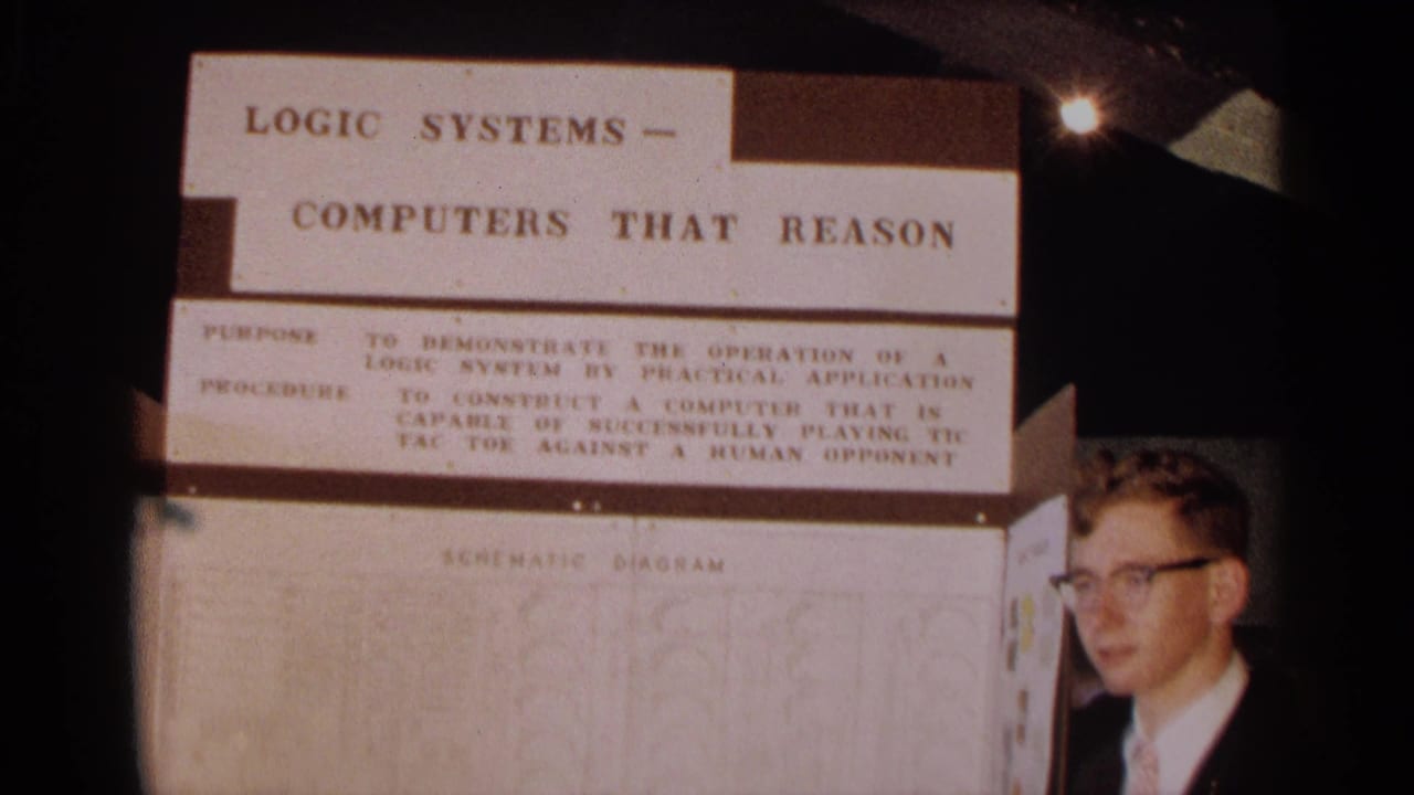 Science fair display on logic systems with a student standing at the right edge.