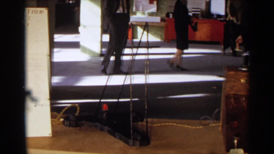 1963 Texas school hallway scene showing visitors walking past the edge of a student science fair display.