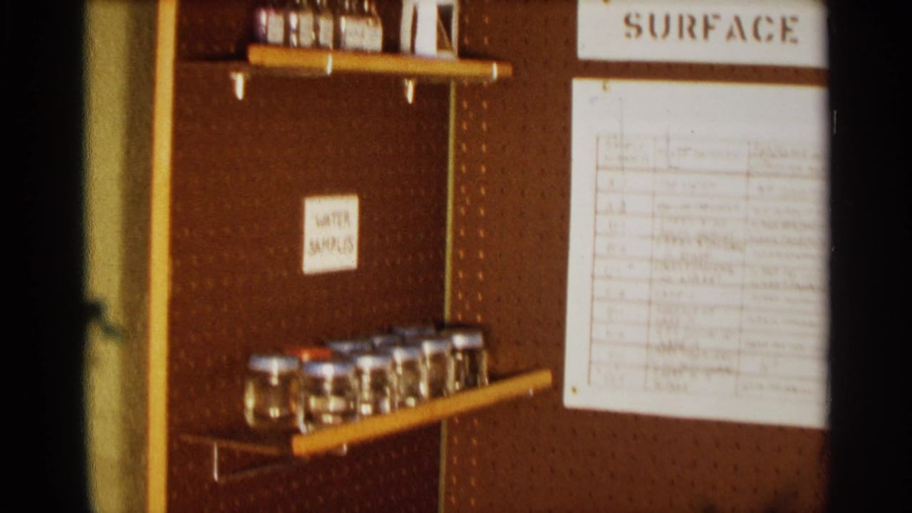Close view of a pegboard display with jars, labels, and a surface-water chart.
