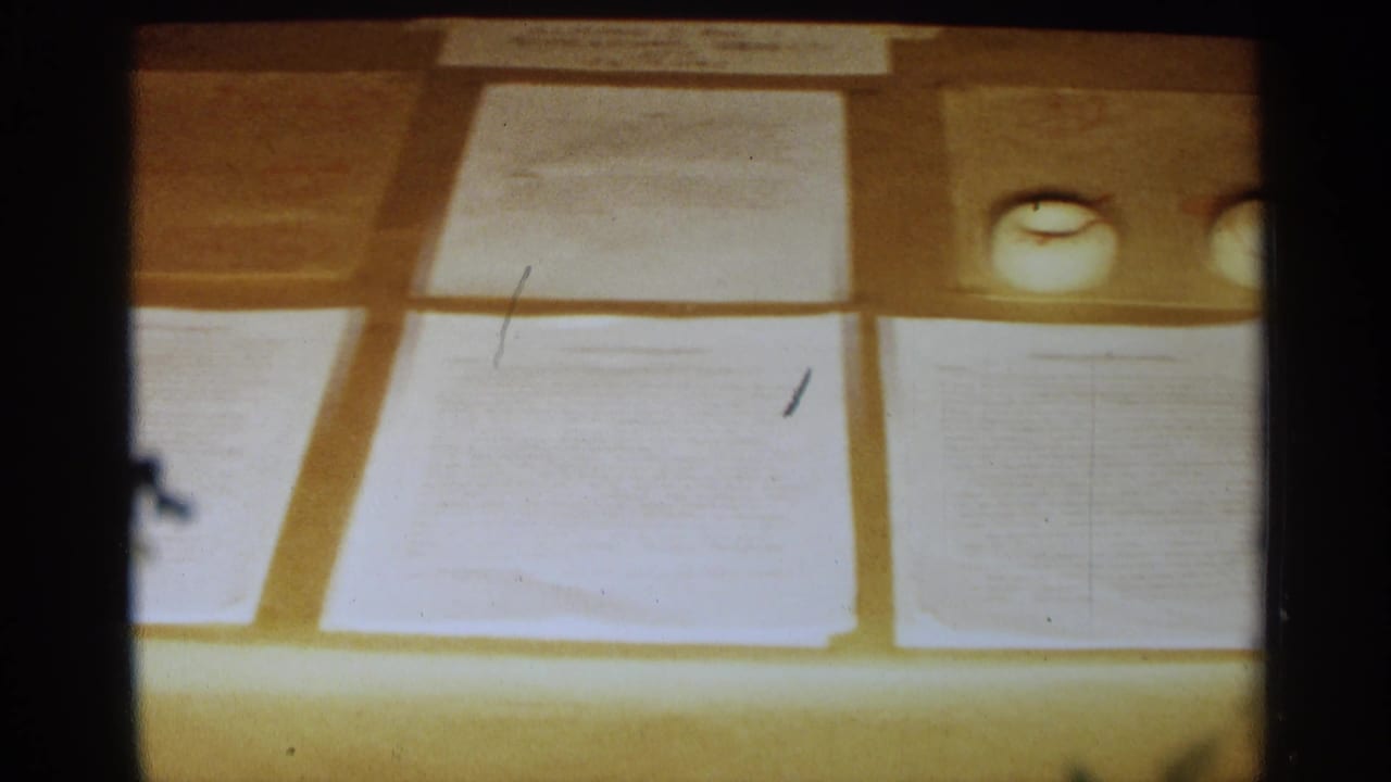 Close view of papers and a display surface under warm projected light.