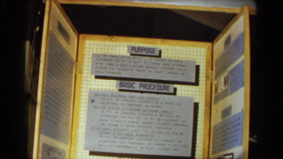 Texas 1963 8mm close view of the exhibit's purpose and basic procedure panels, framed by wood and pegboard.