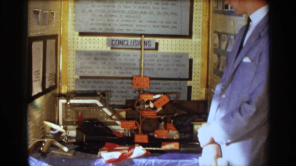 A closer 1963 Texas view centers the CONCLUSIONS panel, wired project parts, and orange labels, with the young man partly cropped at right.