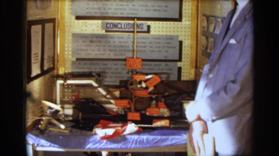 The final frame shows the 1963 Texas science fair project with typed panels, a wired tabletop model, and the young man standing close beside it.