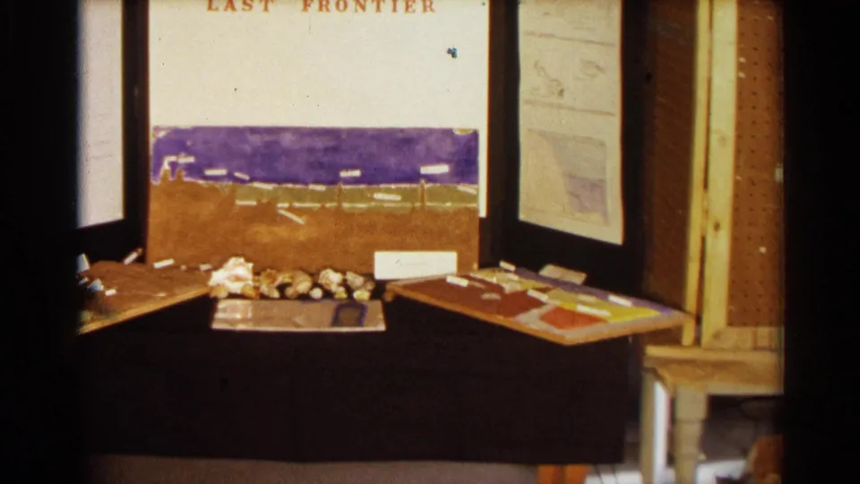 1963 Texas home-movie still of the ocean-themed project display, with painted sea band, shells, labels, and open side panels.