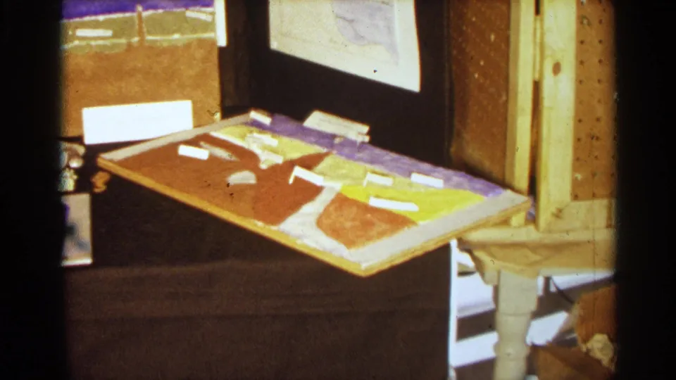 1963 Texas science fair exhibit detail with a colored map-like panel, white labels, display backing, and nearby table structure.