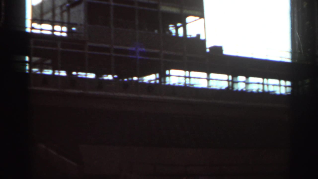 Dark view of empty grandstand structure beside a race track area.