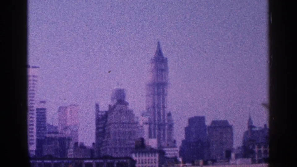 A faded 8mm skyline view of New York City, with the Empire State Building and surrounding towers visible in the distance.