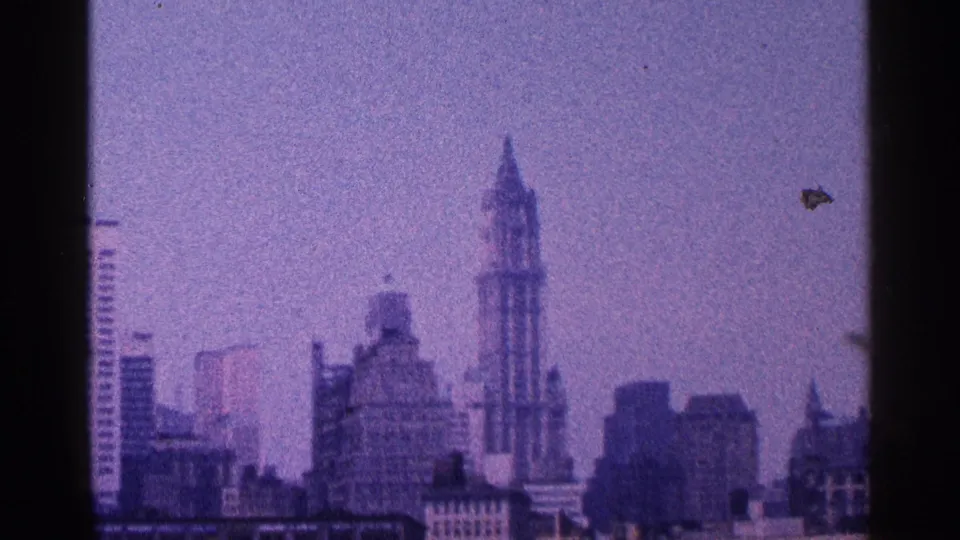 1964 8mm view of a hazy New York City skyline with the Woolworth Building rising near the center.