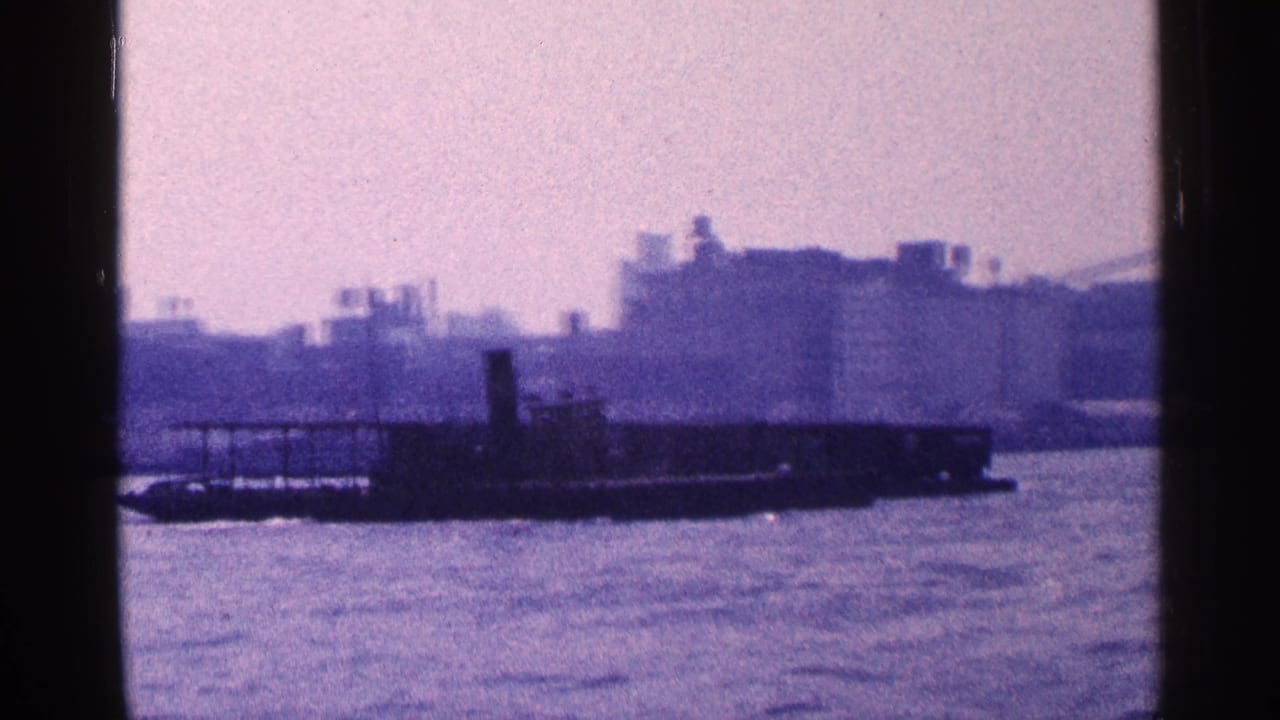 Barge or pier structure on a river with a hazy city skyline in the background.