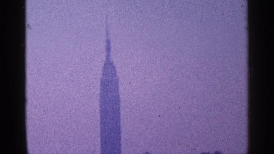 New York City landmark view with the Empire State Building rising above a soft, grainy 1960s skyline.