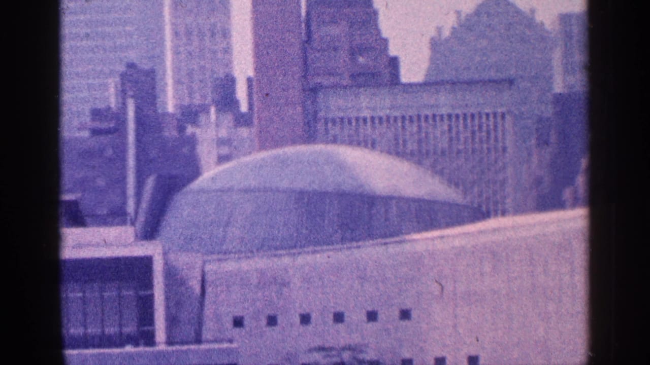 Similar skyline view with domed roof, high-rises, and dark vertical film divider.