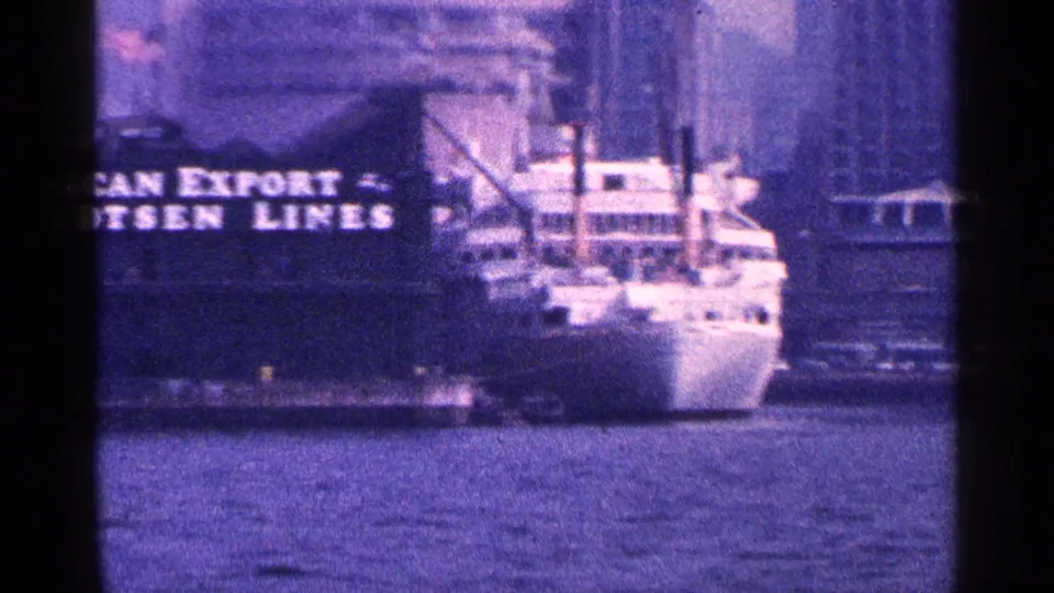 New York City harbor cargo ship stern and superstructure with visible American Export Isbrandtsen Lines lettering in a 1964 8mm frame.