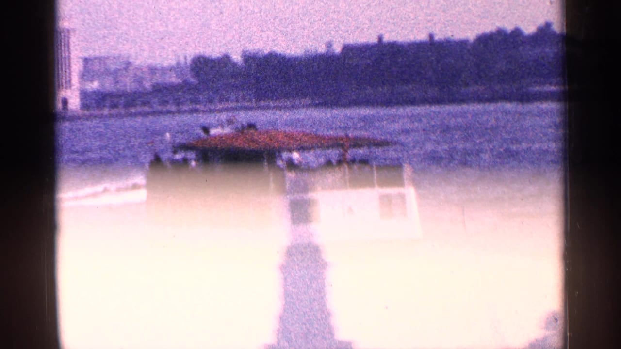New York harbor frame with a ferry passing behind a bright, overexposed silhouette of the Statue of Liberty.