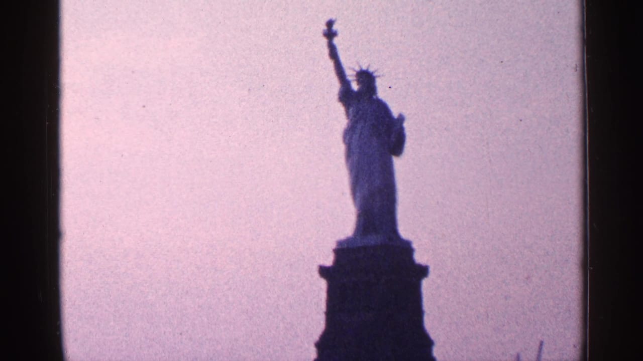 Statue of Liberty silhouetted on its pedestal against a pink-purple sky.