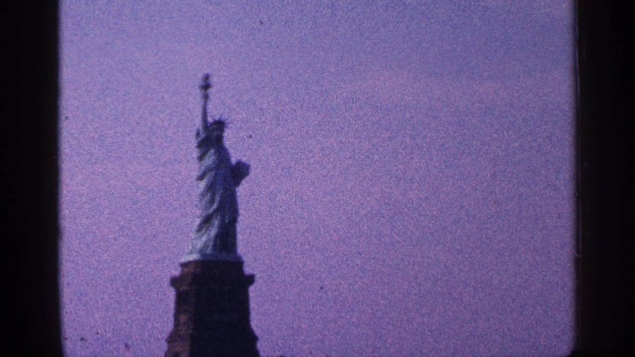 Statue of Liberty seen from below against a purple sky with dark film borders.