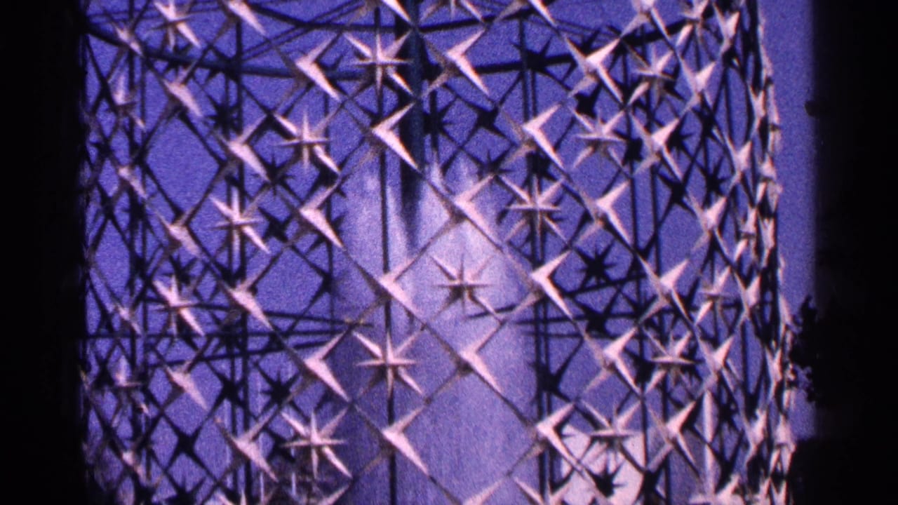 Purple-lit circular fountain lattice with star-shaped metal forms and water spray.
