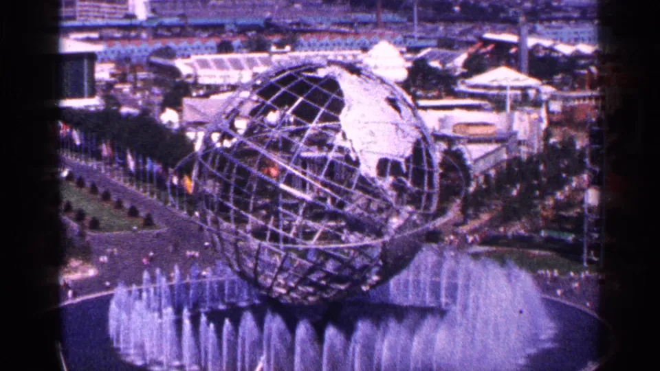 The Unisphere dominates the frame above the circular fountain, with 1964 fairground paths, visitors, and structures visible beyond.