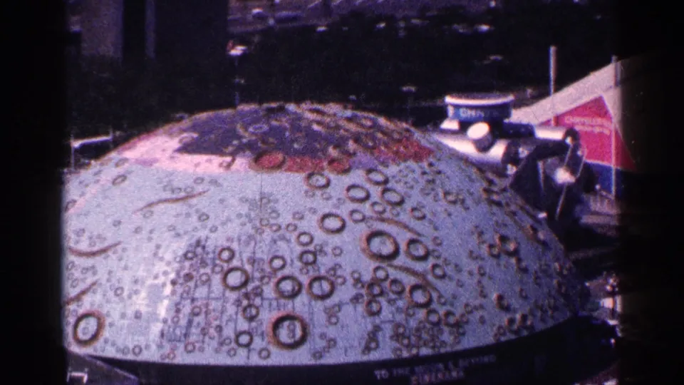 Elevated 1964 New York City view of a large crater-patterned dome beside colorful public-exhibit structures.