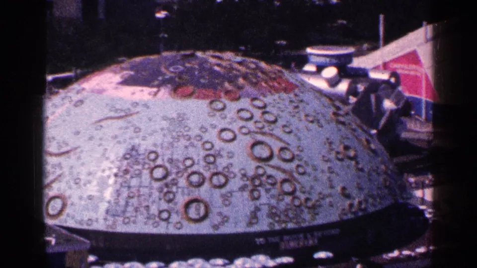 Close elevated view of the crater-patterned dome, with surrounding exhibit architecture partly visible at the frame edge.