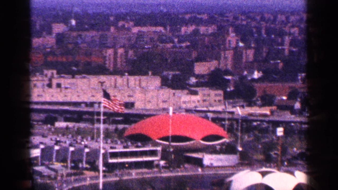 Elevated city view with a red dome-shaped roof and American flag in the foreground.