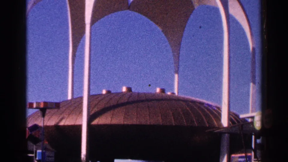 1964 New York City 8mm frame with white arched supports, canopy forms, and a domed roof filling the lower view.