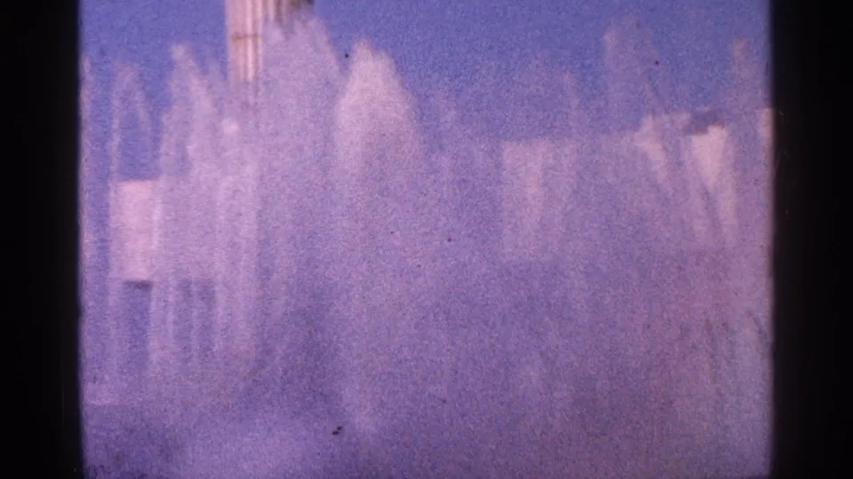 Tall fountain water jets dominate this 1964 New York City home-movie frame, with a washed blue sky and heavy film borders.