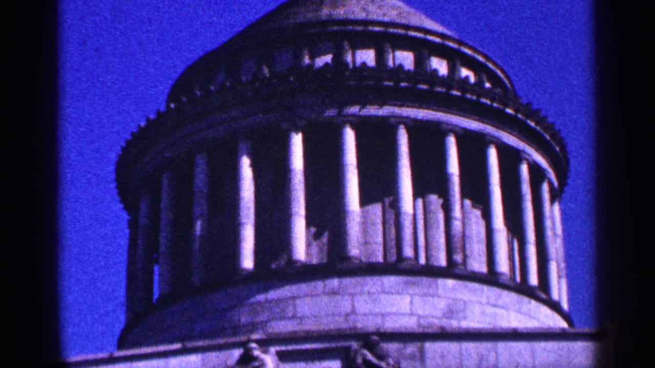 Domed classical building with columns seen against a blue sky.