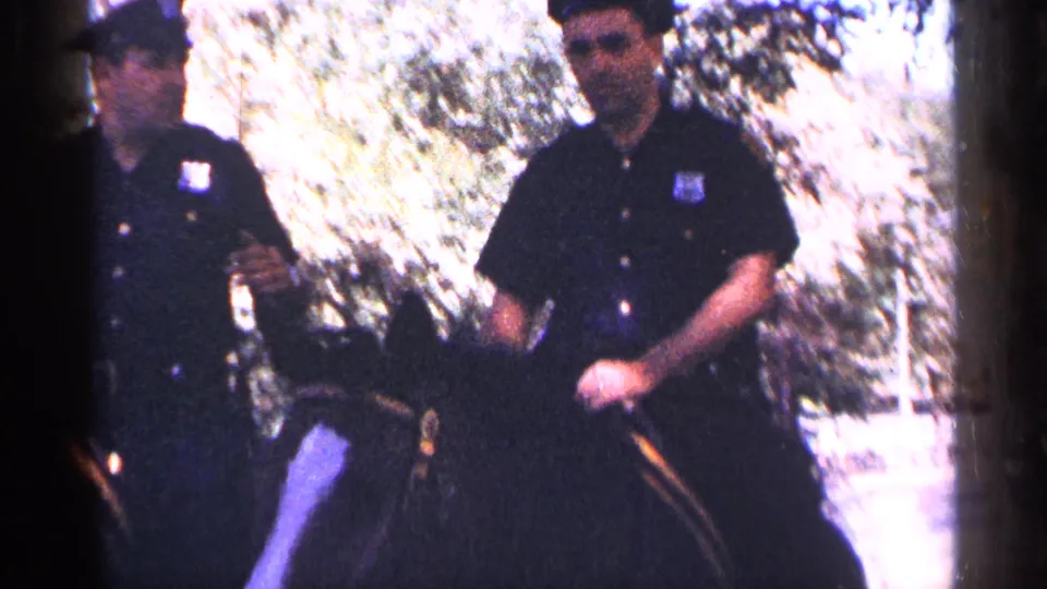Mounted police officers on horseback move through a shaded public area near Rockefeller Center, based on the clip metadata.