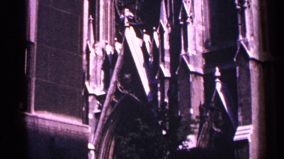 1964 New York City 8mm frame showing an ornate Gothic-style arch, adjacent wall surface, and exterior stone details.