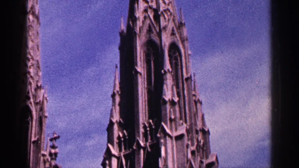 1964 New York City 8mm view of cathedral towers, pointed arches, and vertical stone details against open sky.
