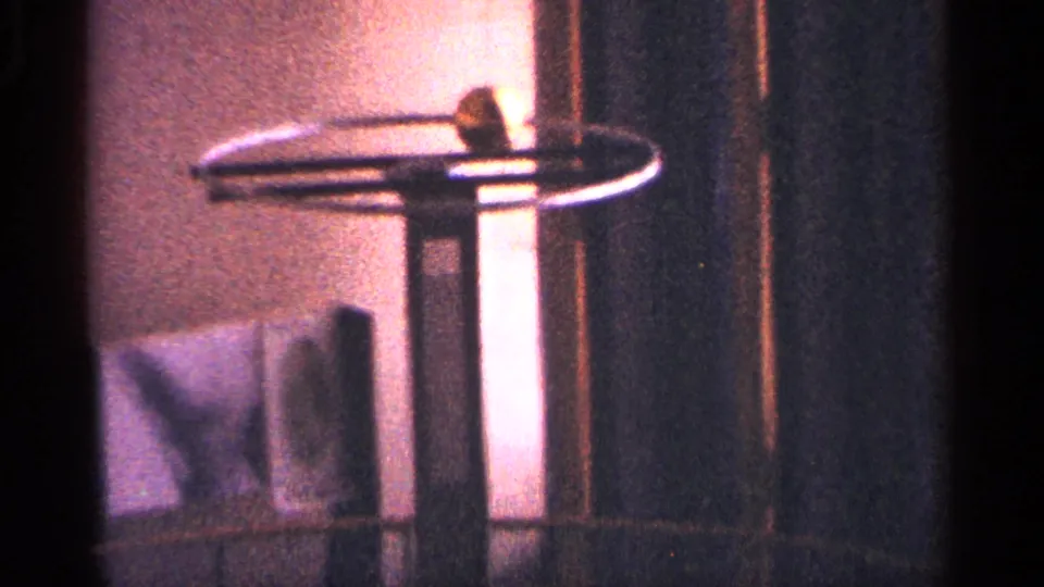 Warm interior detail in the New York City home movie, with a spinning object silhouetted against walls and dark trim.