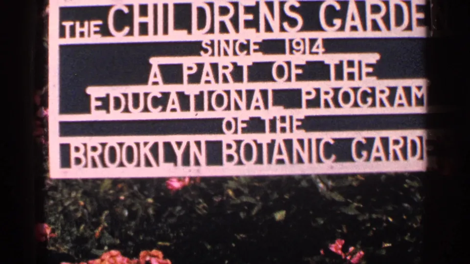 Close 8mm view of the Children's Garden sign at Brooklyn Botanic Garden, with some text cropped by the frame edge.