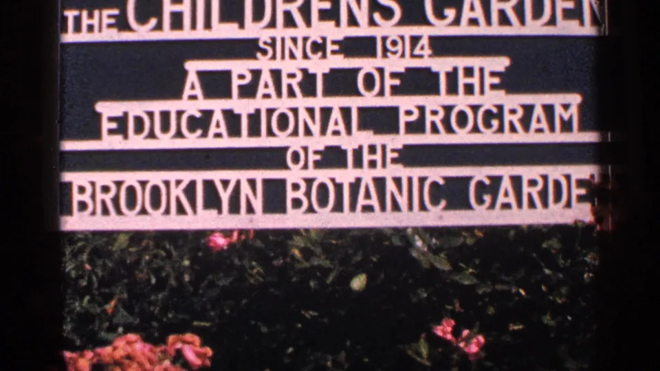 Centered 1964 home-movie frame of the Children's Garden sign for Brooklyn Botanic Garden's educational program.