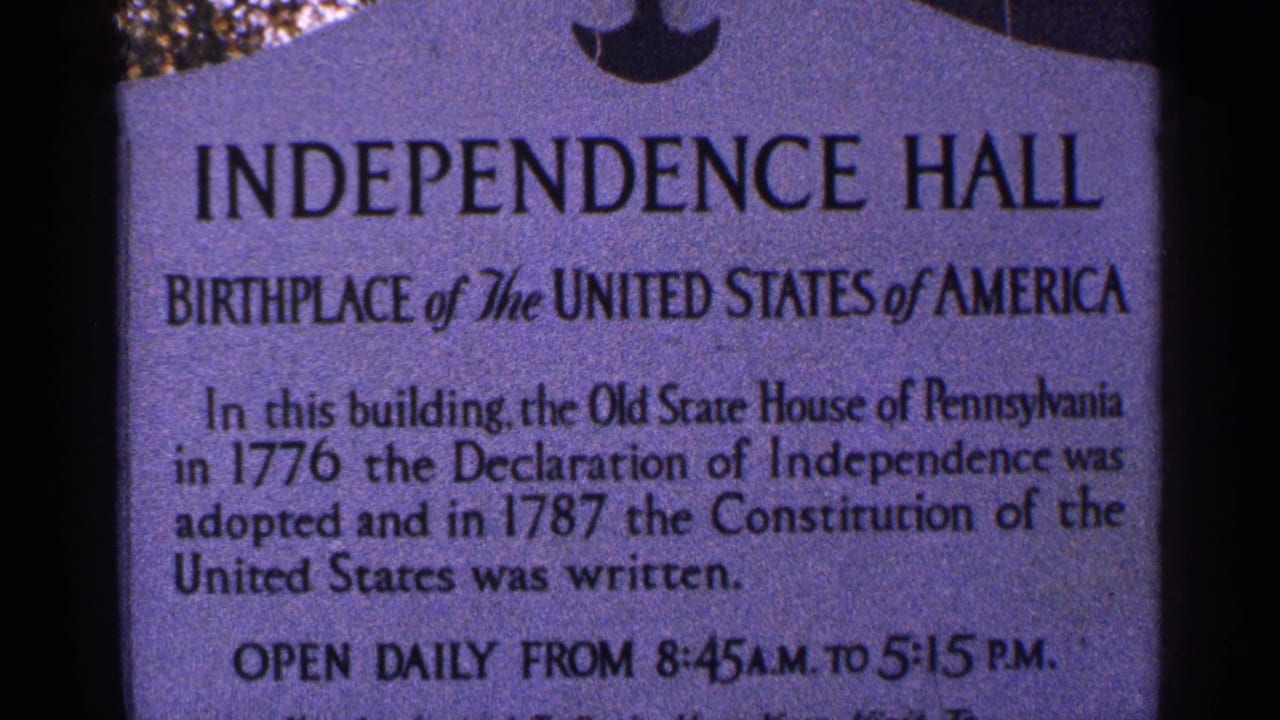 1964 8mm close-up of an Independence Hall historical marker with legible text about the Declaration of Independence and Constitution.