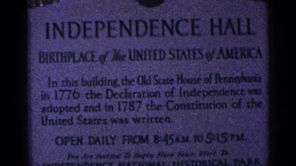Close 8mm frame of the Independence Hall marker, showing the title, birthplace line, founding-history text, and visitor hours.