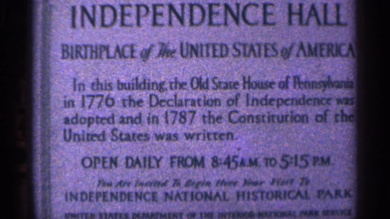 Close view of an Independence Hall sign at the Philadelphia historic site, photographed on grainy 8mm film.