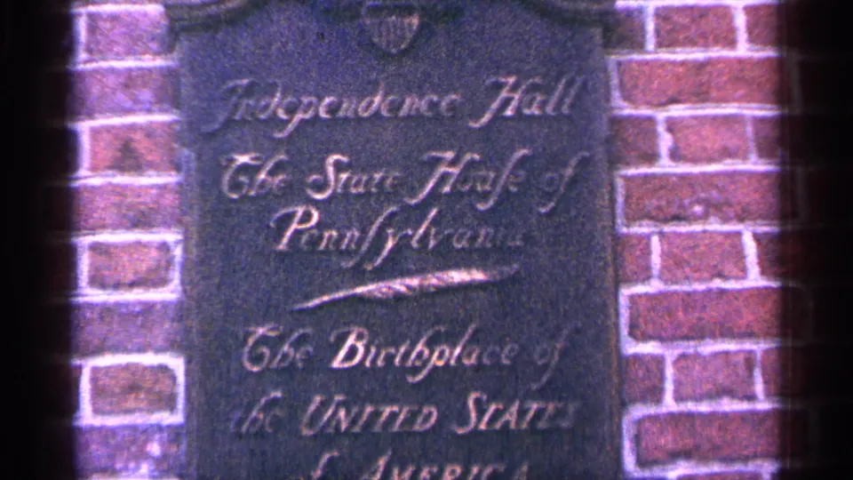 Close-up of an engraved Independence Hall plaque set into brick, identifying the site as the State House of Pennsylvania.