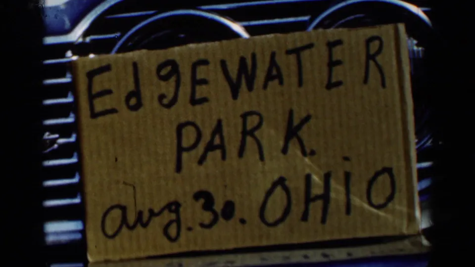 Handwritten Edgewater Park, Aug. 30, Ohio card set against a car dashboard, with chrome trim partly visible.