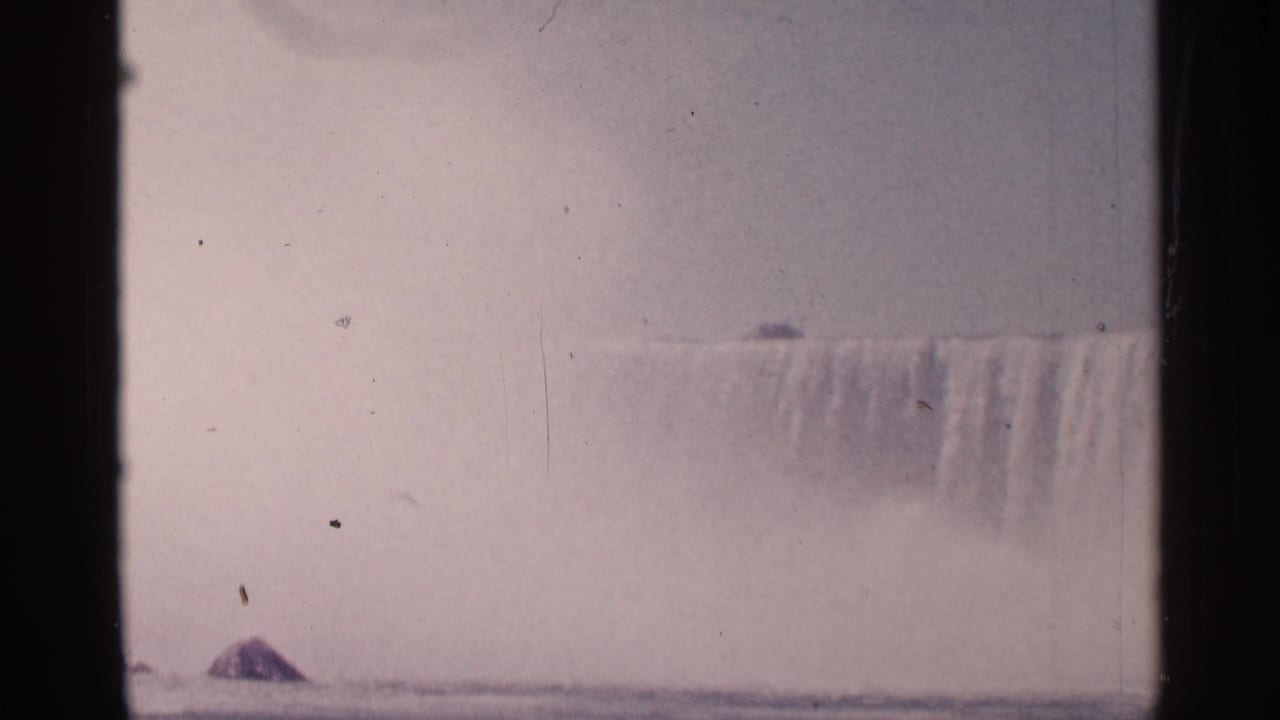 Distant Niagara Falls through mist with dark 8mm frame borders and film specks.