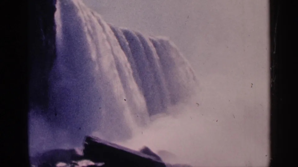 1964 8mm frame of Niagara Falls, Canada, with water plunging over the edge and mist softening the lower view.