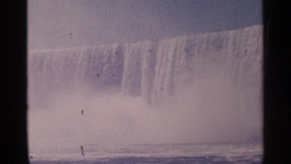 Niagara Falls appears in faded 1964 8mm color, with the cascade cresting over the rim and mist filling the lower view.