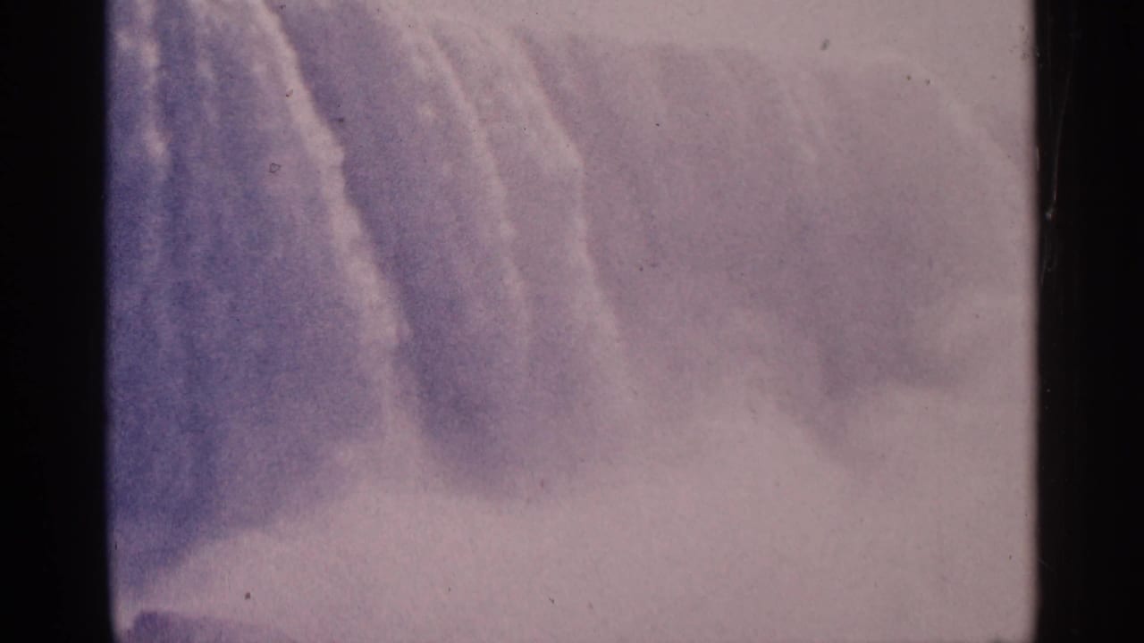 Cascading water and spray appear softly through faded color and film grain.