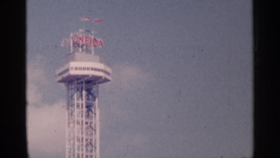 Soft 8mm frame of a Niagara Falls observation tower with visible red rooftop signage and a tall steel support structure.