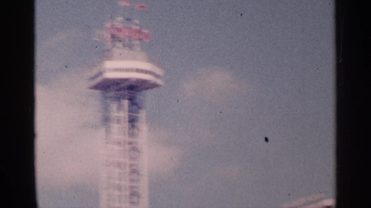Blurred 8mm view of the tower's upper section, with red lettering visible above a circular deck in Niagara Falls, Canada.