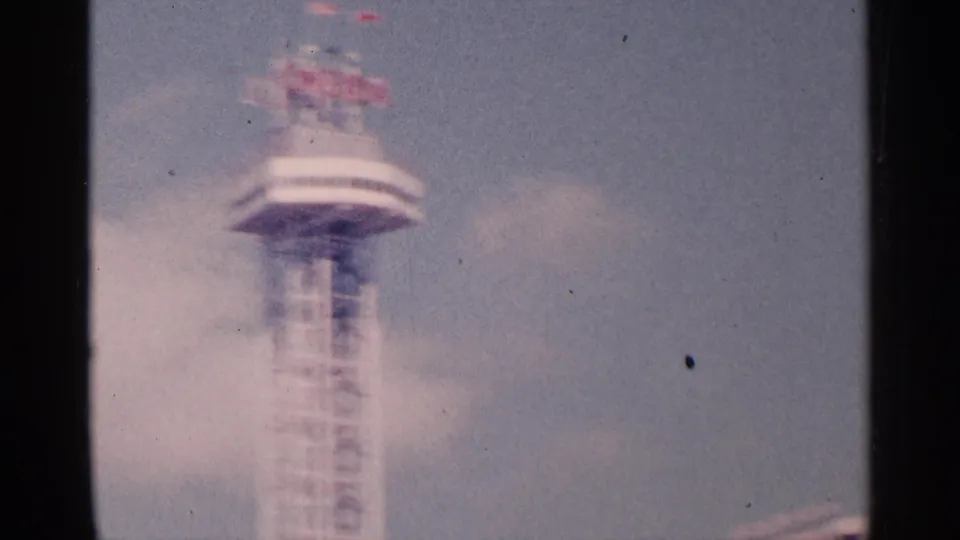 Blurred 8mm view of the tower's upper section, with red lettering visible above a circular deck in Niagara Falls, Canada.