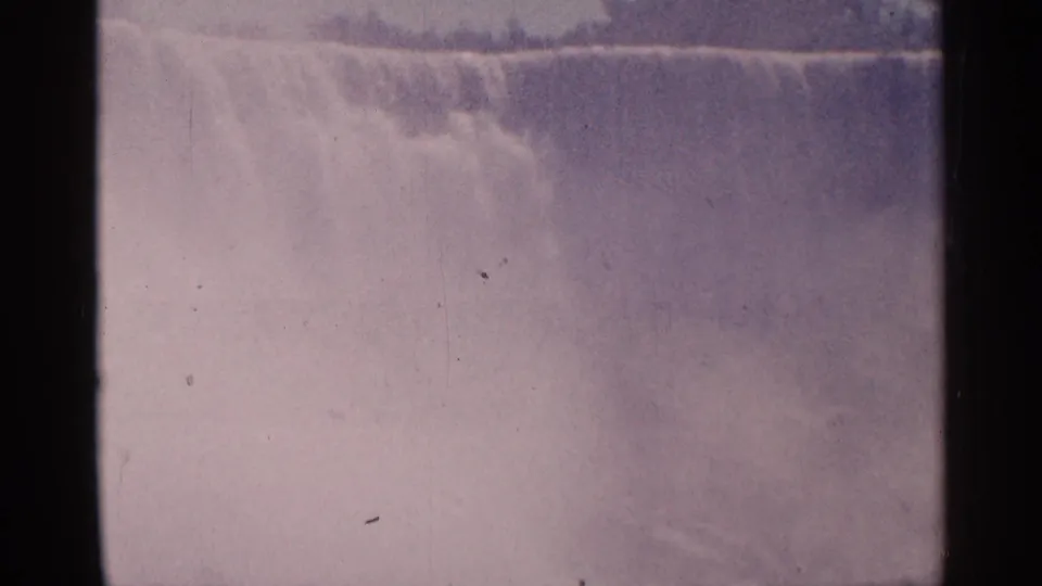 Visitor-shot 1964 8mm footage shows the crest and mist of Niagara Falls in Canada, with faded color and dust marks.