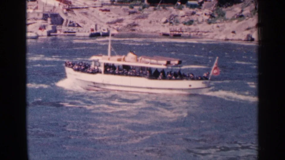 Crowded tour boat on the Lower Niagara River near Niagara Falls, Canada, seen in faded 1960s 8mm color.
