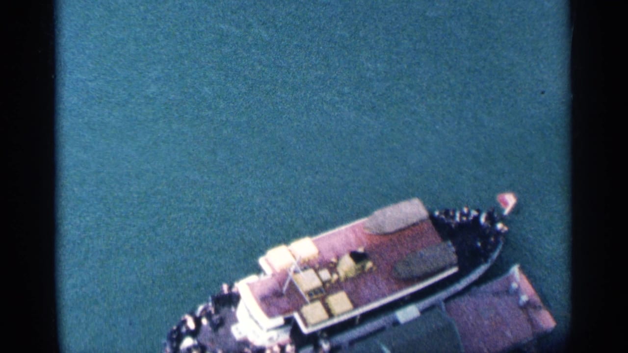 Passenger boat near the edge of the frame on calm blue water.