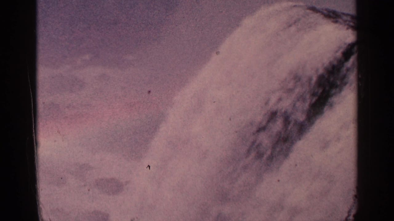 Close view of a large waterfall cascade with mist and dark film borders.