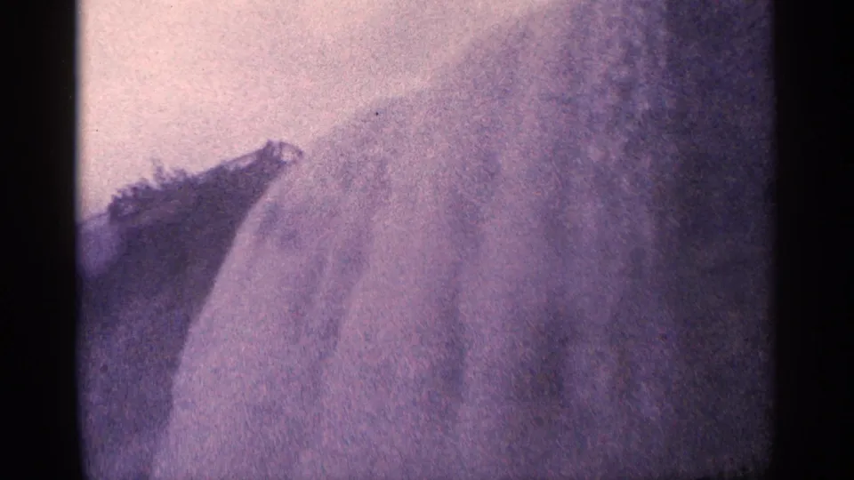 Final 1964 Niagara Falls home-movie frame showing heavy spray, pale rushing water, and a dark rock ledge inside the 8mm frame.